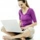 A career-focused woman sitting on the floor using a laptop.