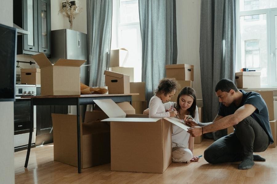 A family moving house and unpacking boxes in their new home. A family moving house and unpacking boxes in their new home.