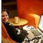 A woman working on her laptop as she returns to her career.