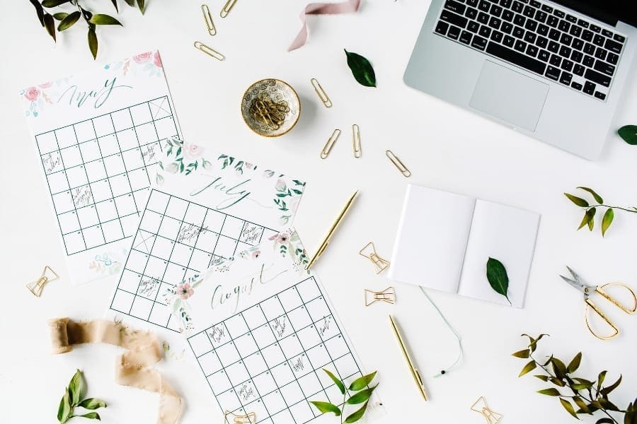 A career-focused mum's desk with a laptop and calendars on it.