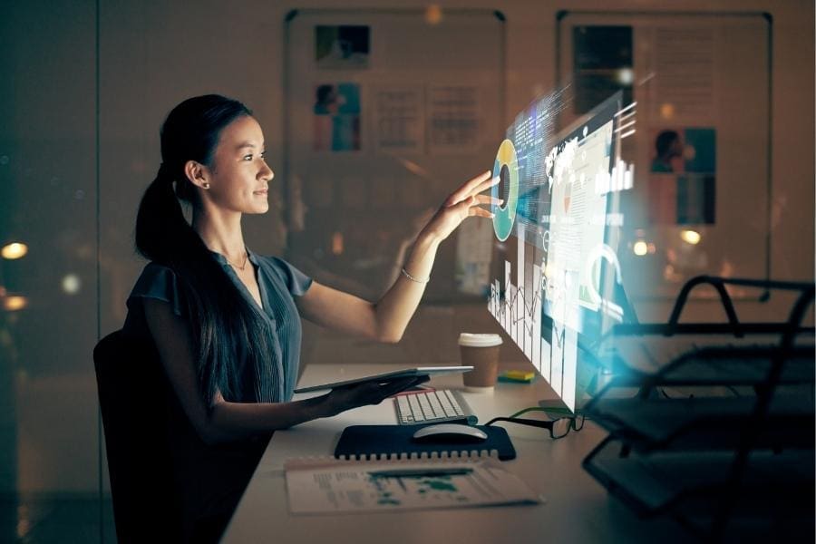 A woman is working on her computer screen late at night, determined to restart her career as a working professional.