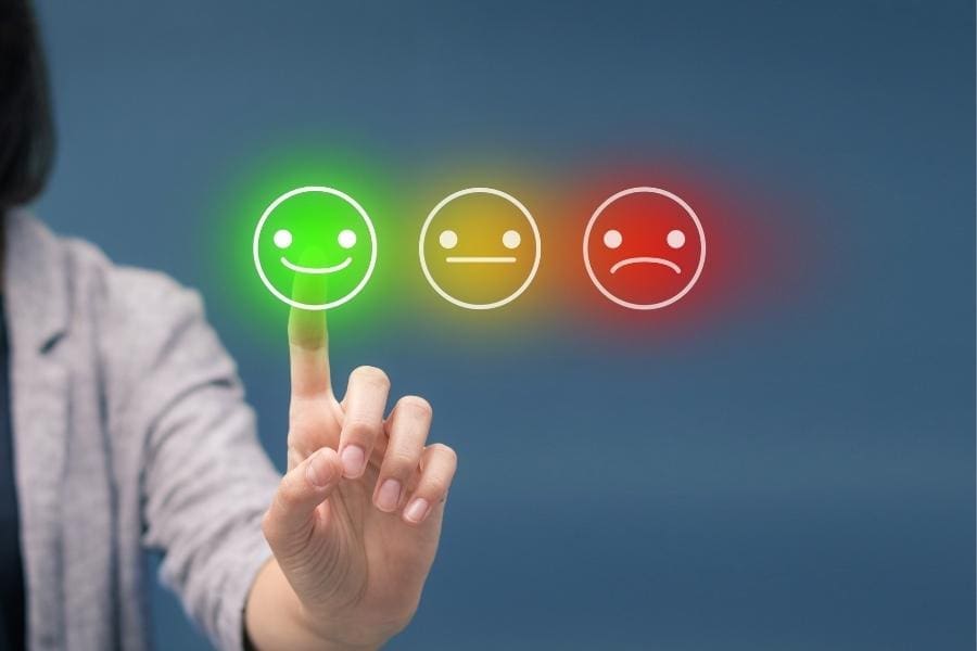 A woman is pointing at a colorful smiley face as part of her job in the field of working and career.