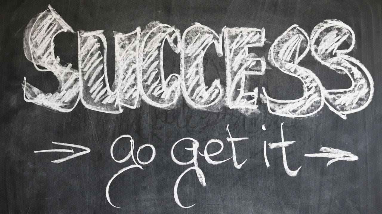 The words "SUCCESS go get it" are written in large, chalky white letters on a black chalkboard, with arrows pointing toward the phrase—inspiring you to pursue professional growth and advance in your work field.