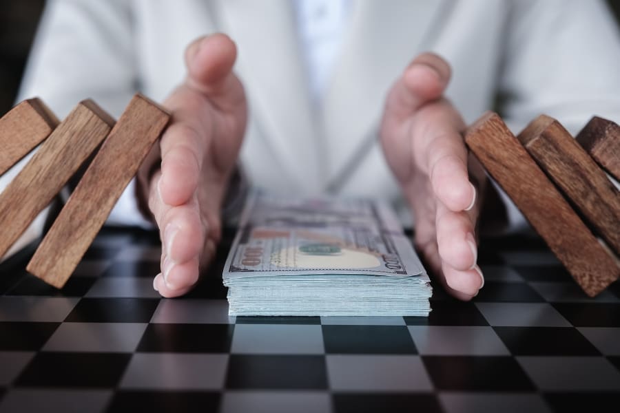 A businessman holding a stack of wooden dominoes.