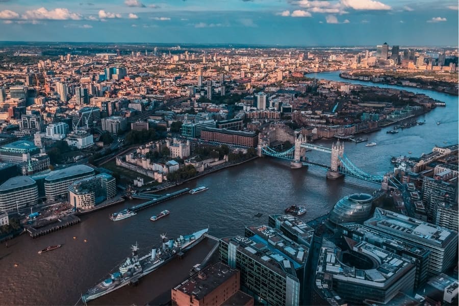 Aerial view of London in April 2025, featuring the River Thames, Tower Bridge, and a vibrant cityscape buzzing with employment news.